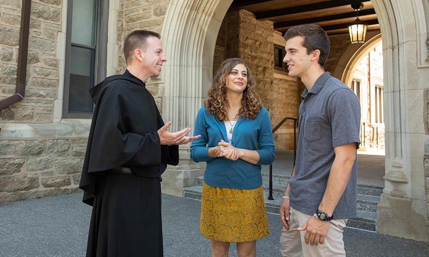 Father DePrinzio speaks with members of the community outside of Corr Hall.