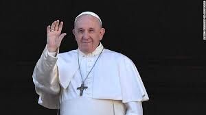 Pope Francis smiles at a crowd.