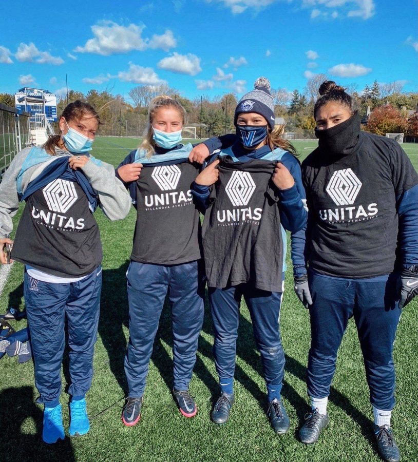 The women’s soccer team showcases their shirts at practice to celebrate UNITAS Day. 