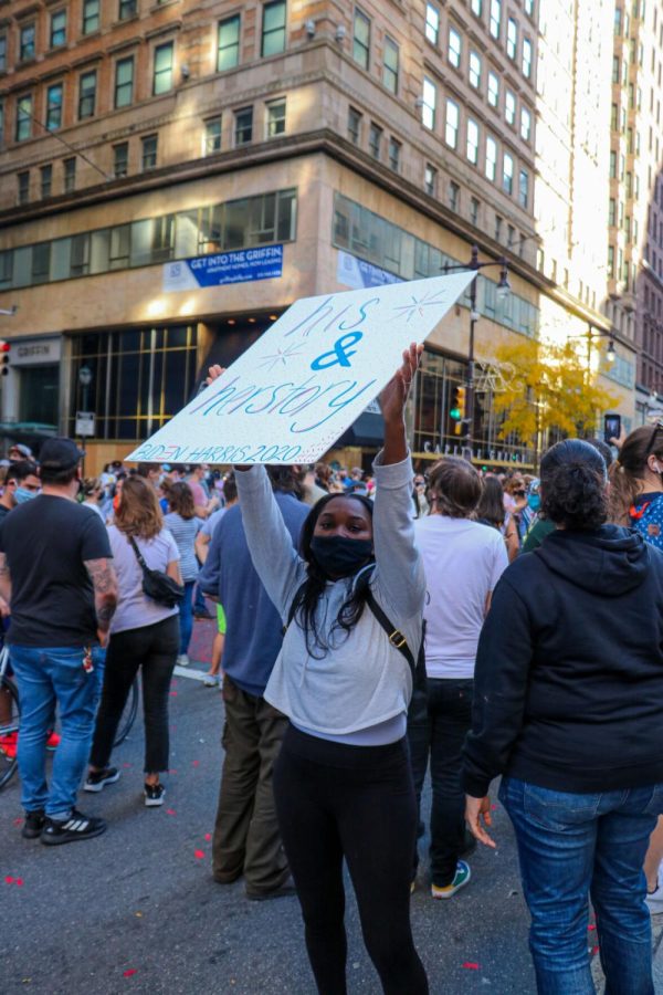 A girl holds sign reading “His & Her Story, Biden Harris 2020” at a celebration in Center City on Saturday, Nov. 8, 2020. 