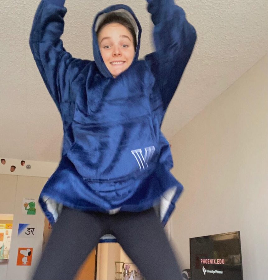 Junior Annie Reilly jumps for joy, wearing her Campus Cozy.