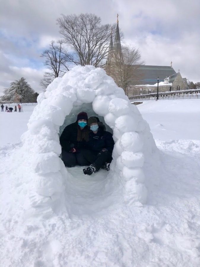 Julia Weicht (on left) and Jenna Kolano (on right)  pose by their completed igloo.