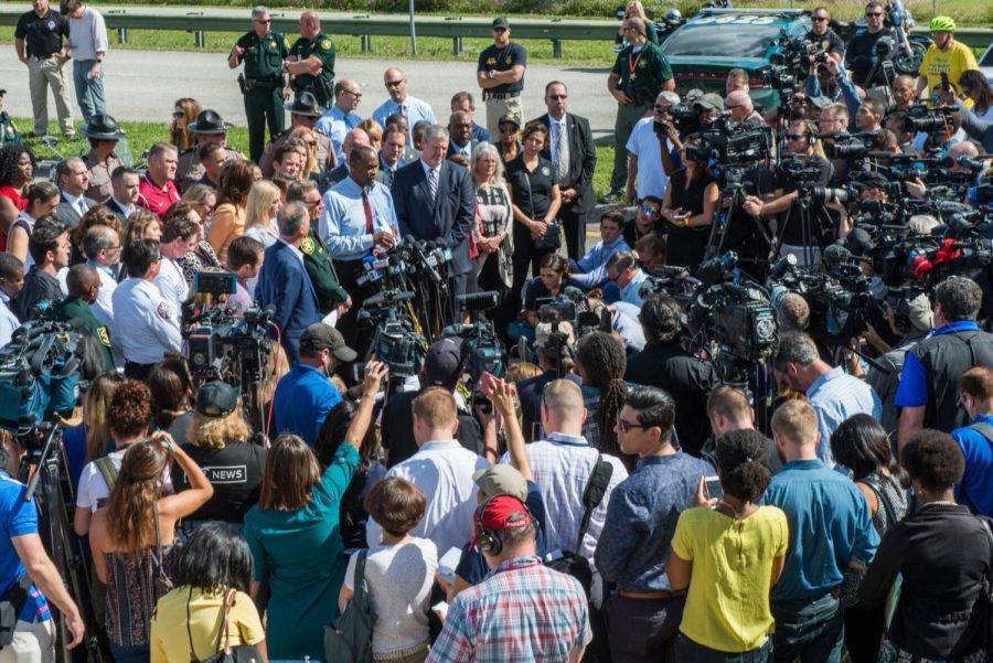 Media covering a press conference following a shooting event. 