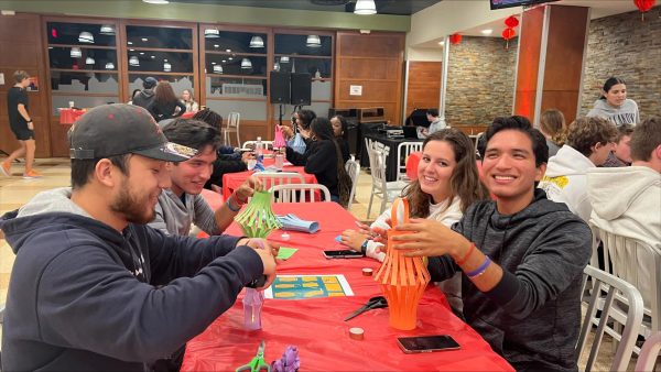 Students make paper lanterns at a celebration for the Mid-Autumn festival in Cafe Nova.
