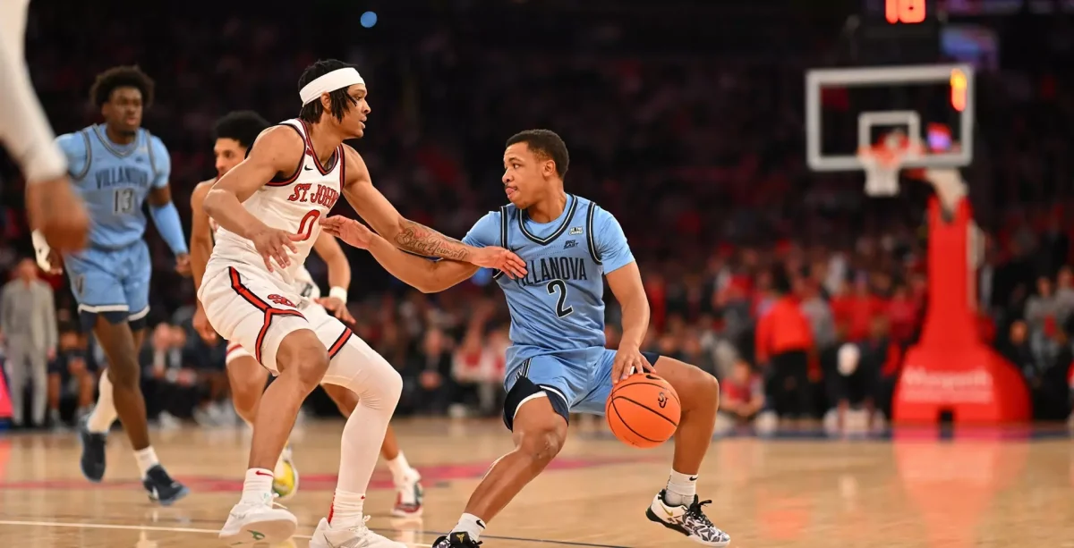 Graduate guard Jhamir Brickus dribbles the ball at the top of the arc.